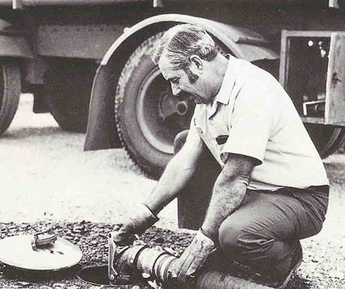 Vintage photo of truck driver filling underground fuel tank